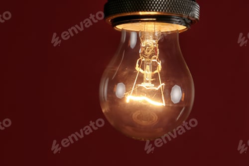 Preview: Pendant lamp with light bulb against dark red background, space for text