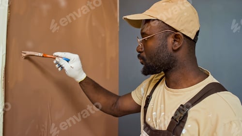 Preview: African American Painter Using Brush on Wall Wearing Cap