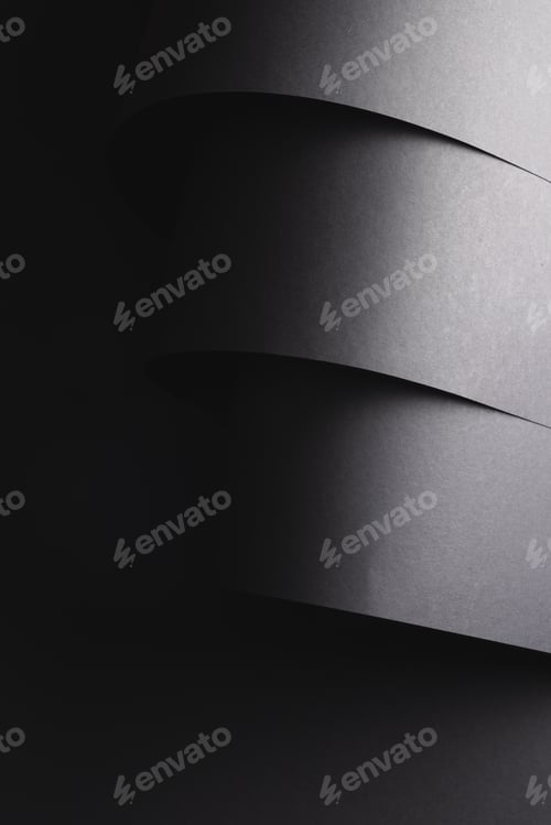 Preview: Vertical image of close up of layers of pieces of black paper with copy space on black background