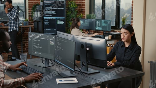 Preview: Two focused coders facing each other writing code in software development office