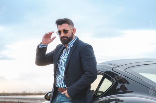 Preview: Handsome elegant male leaning on his sports car