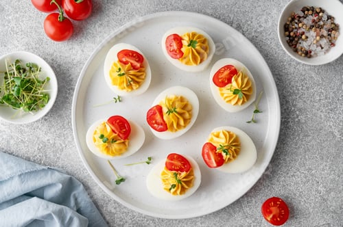 Preview: Deviled eggs with cheese, mustard and microgreens on top on a plate for Easter.