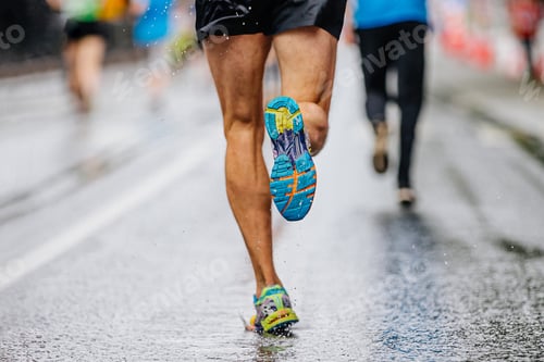 Preview: close-up runner athlete run marathon race on wet asphalt, water drops on sole running shoes