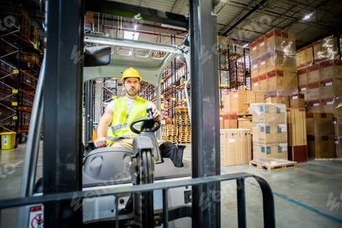 Preview: Forklift operator during work in large warehouse