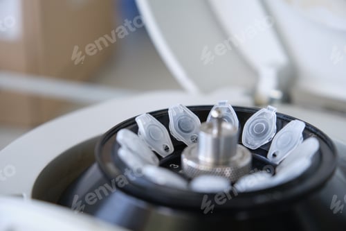 Preview: Close up of small tubes eppendorfs on a mini centrifuge in a laboratory. Minispin full of tubes.