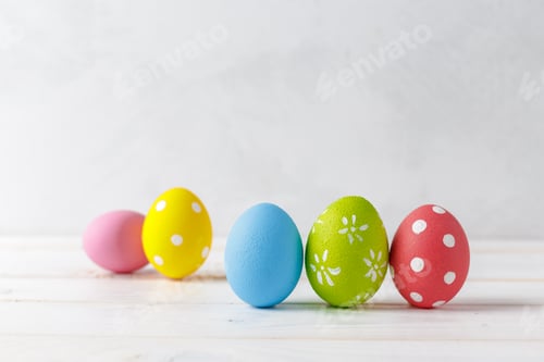 Preview: Colorful decorated eggs arranged on a light wooden surface for a festive spring celebration