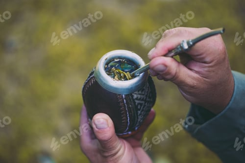 Preview: Man holding yerba mate in nature. Travel and adventure concept. Latin American drink yerba mate