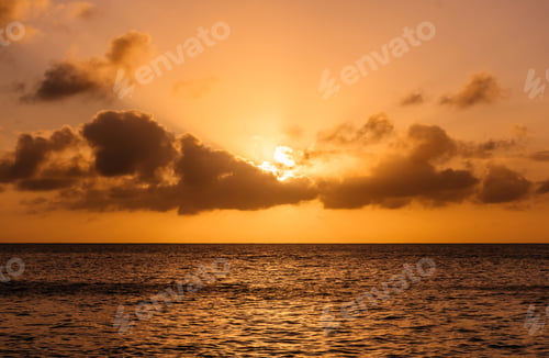 Preview: Amazing sky with sun behind clouds above horizon over ocean
