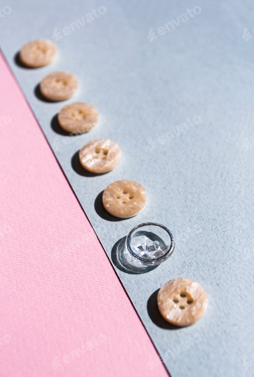 Preview: A row of buttons, one of them special, lies on a blue and pink background. Minimalist concept.