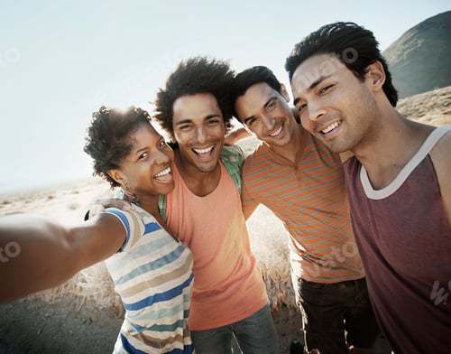 Preview: A group of friends, men and women, heads together posing for a selfy in the heat of the day.