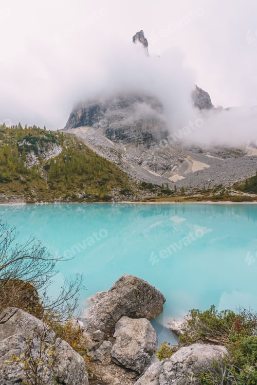 Preview: A rocky shoreline with a body of water that is blue in color lake sorapis dolomites