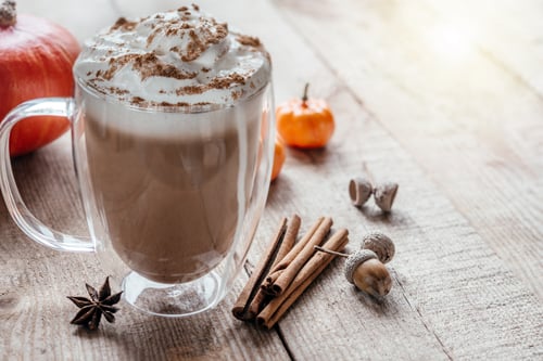 Preview: Autumn spiced latte with whipped cream and cinnamon on wooden background