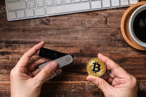 Preview: hand holding hardware wallet and transfer bitcoin and ethereum crypto currency to wallet for safety