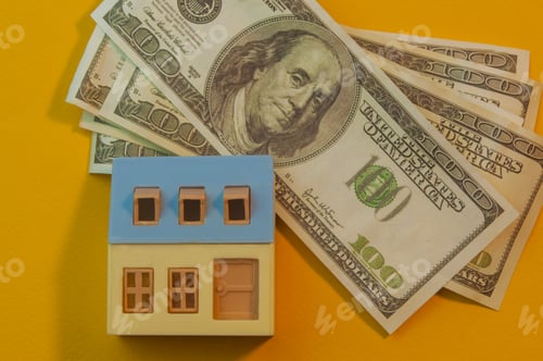Preview: a small yellow house stands on a yellow background next to a lot of money.