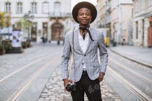 Preview: African man posing on street with retro photo camera