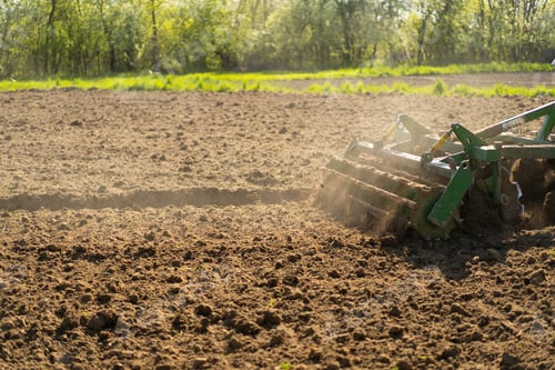 Preview: The tractor drives across the field and cultivates the land.
