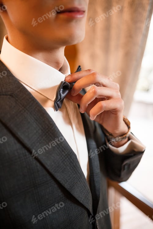 Preview: Man Adjusting Bowtie Before Event