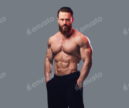 Powerful Muscular Man Posing Against a Gray Background