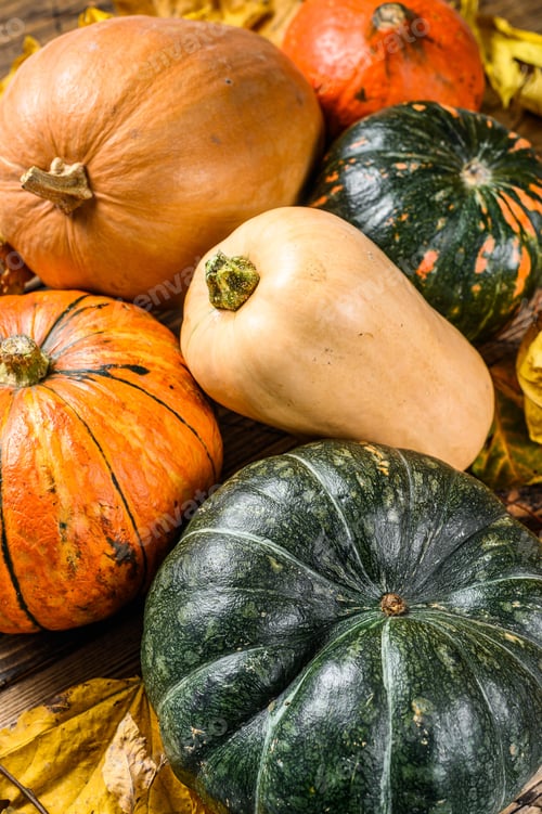 Preview: Autumn Pumpkins with maple leaves on wooden table. Wooden background. Top view