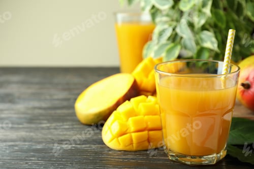 Preview: Ripe mango fruit and juice on wooden table