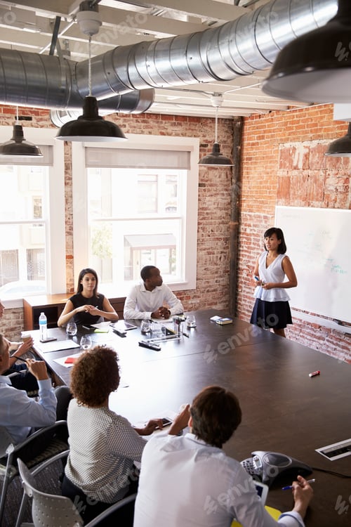 Preview: Businesswoman At Whiteboard Giving Presentation In Boardroom