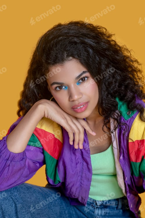 Preview: Pretty dark-haired young girl in jeans looking thoughtful