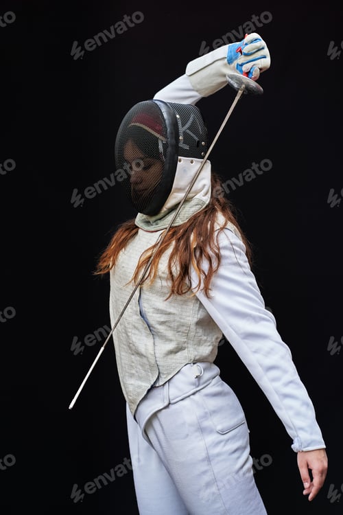 Preview: Portrait of woman dressed in fencing costume on black background