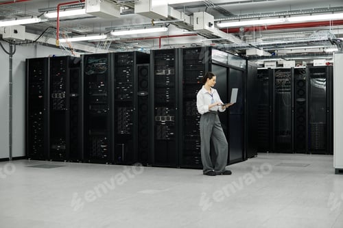 Preview: Professional woman works diligently in a sleek server room overseeing digital operations.