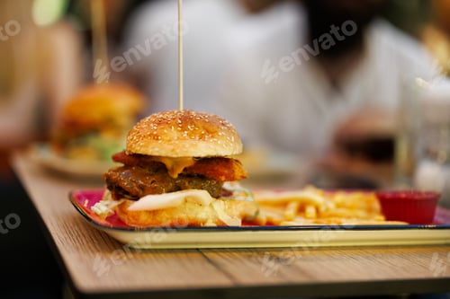 Preview: Burger with fries on a plate on a table in a restaurant