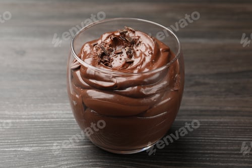 Preview: Delicious chocolate pudding in glass on wooden table, closeup
