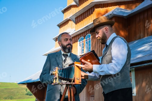 Preview: Photographer with model are preparing a large-format retro camera to shooting