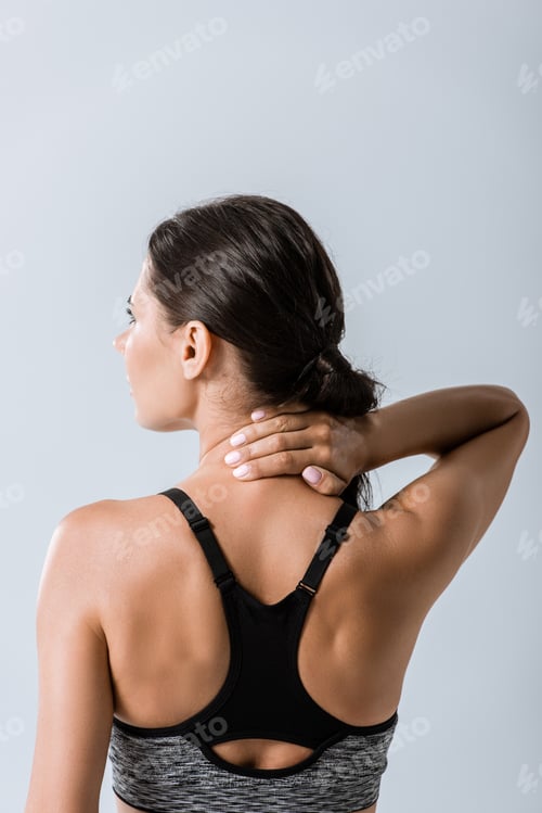 Preview: back view of sportswoman with neck pain isolated on grey