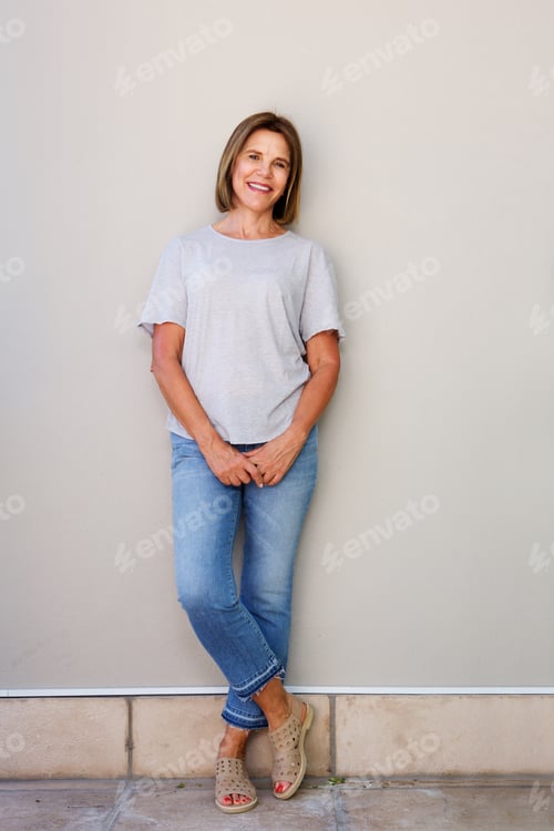 Preview: smiling elderly woman leaning against wall