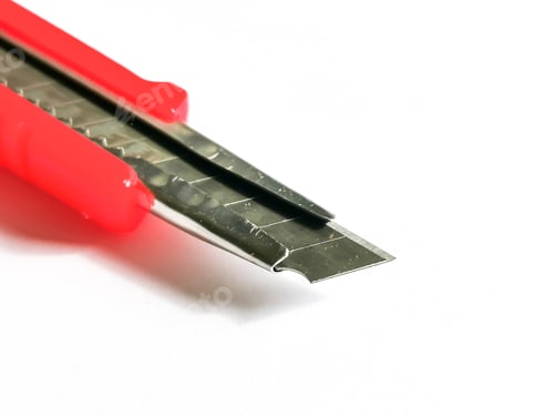 Preview: Close up photo of red utility knife isolated on white background.