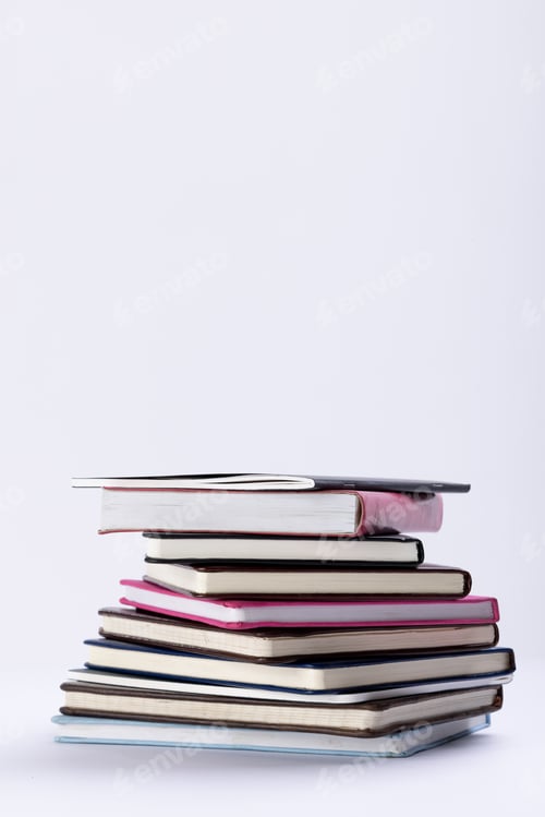 Preview: Close up of stack of books and notebooks with copy space on white background