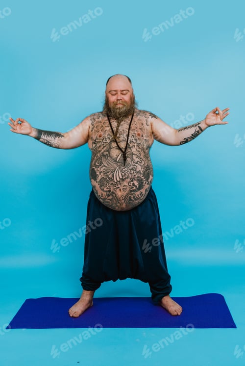 Preview: Hipster man with tattoos doing yoga and meditation exercises in the morning