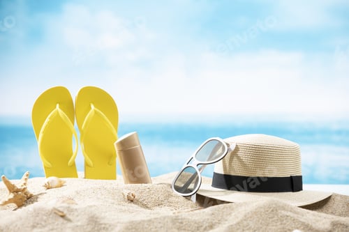 Preview: Bottle of beer, slippers, a hat, sunglasses and a starfish on the sand on the ocean background