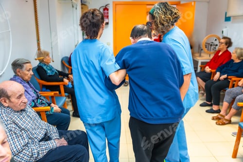 Preview: Nurses helping a man in the gym of a geriatrics