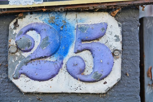 Preview: Number 25 street sign with purple paint on a white rustic metal surface