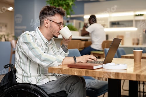 Preview: Businessman with disability working online in cafe