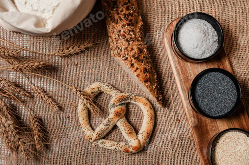 Preview: Freshly baked bagels and bread served on a wooden board surrounded by salt.