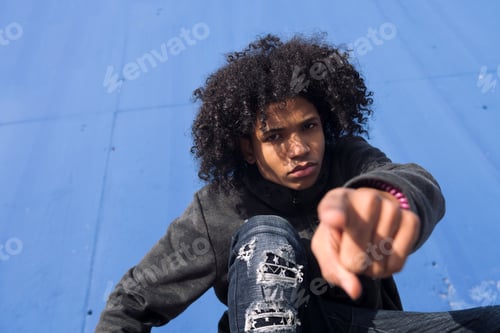 Preview: Serious black hipster teenager pointing at camera