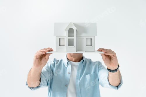Preview: obscure view of man showing house model isolated on white