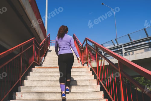 Preview: back view young woman running on the stairs, sport concept