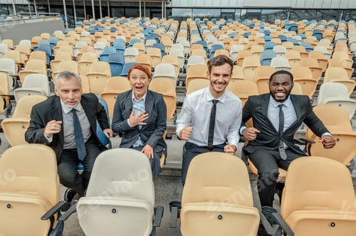 Preview: Group of business people sitting on plastic seats of stands at stadium