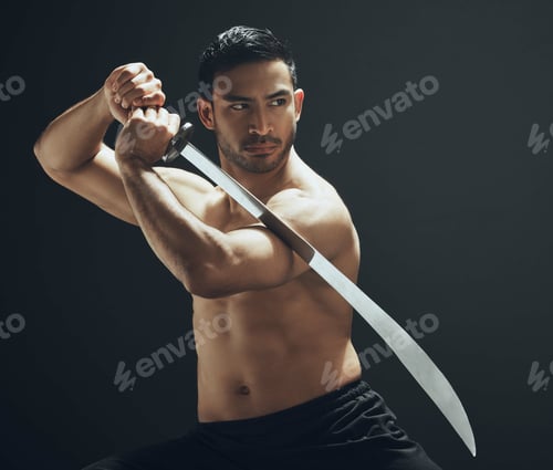 Preview: Shot of a handsome young man standing alone in the studio and posing with a broadsword