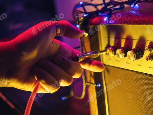 Preview: Mans hand plug in jack to guitar amplifier