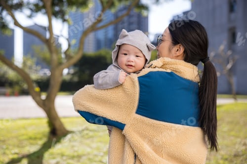 Preview: Smiling baby in mothers arms outside