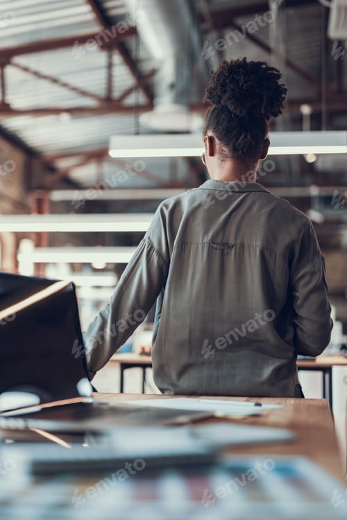 Preview: Back View Portrait Of Young Lady Sitting At The Corner Of Table On Blurred Background