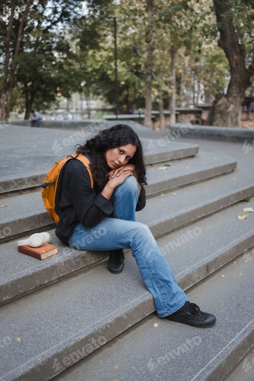Preview: Young female student feeling lonely and sad outdoors